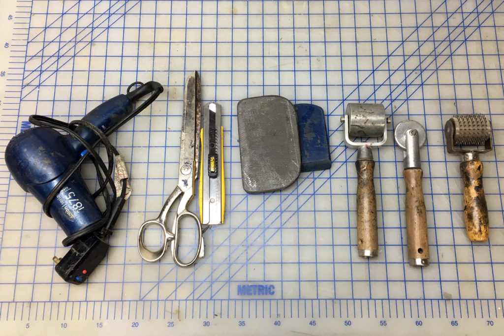 prepreg laminating tools: heat gun/hairdryer, scissors, razor knife, push sticks/dibbers, rollers, spiky roller.