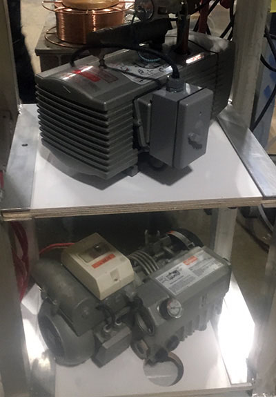 two vacuum pumps on a cart - one high vac and one low